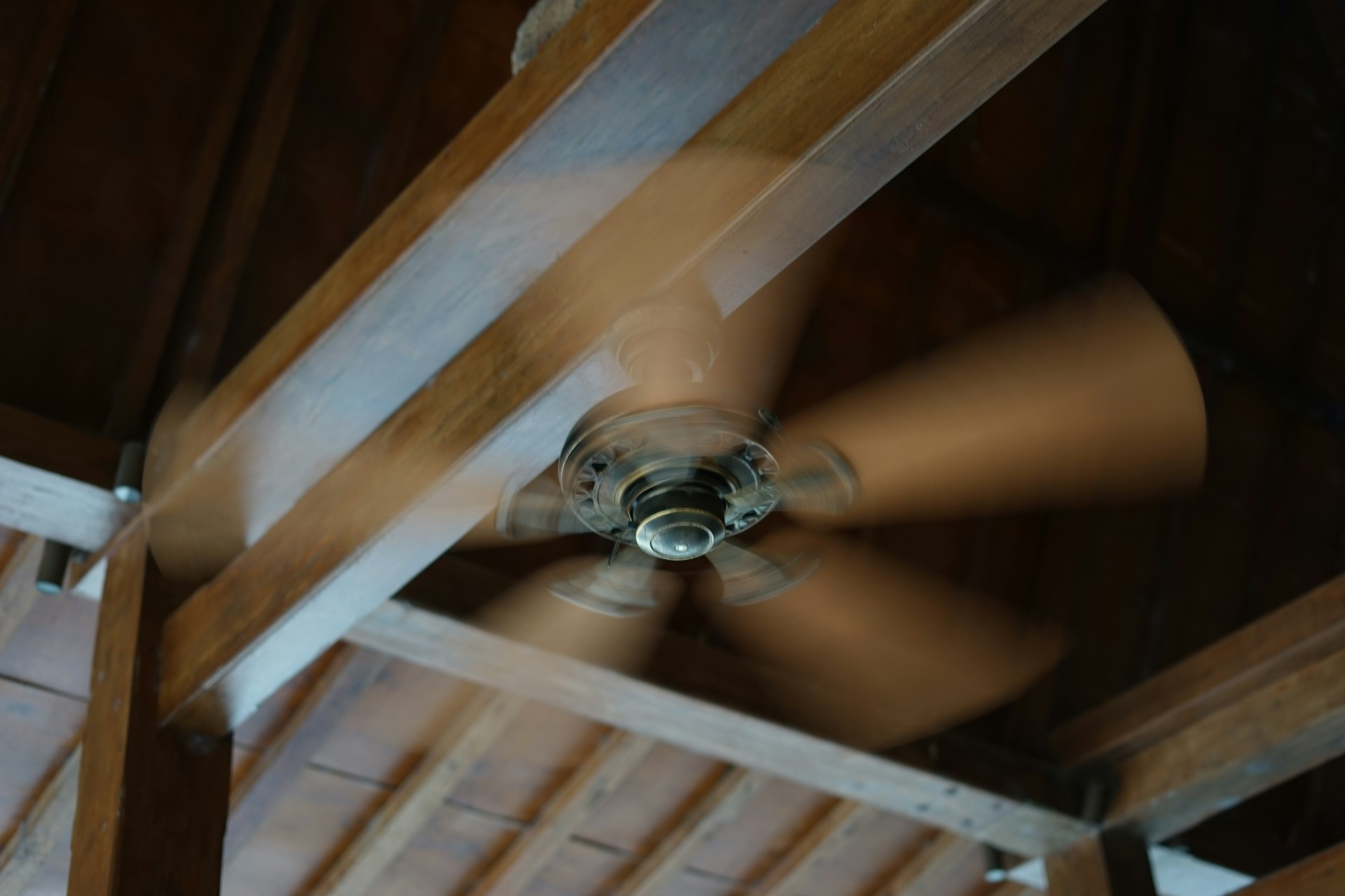A wooden ceiling fan in motion