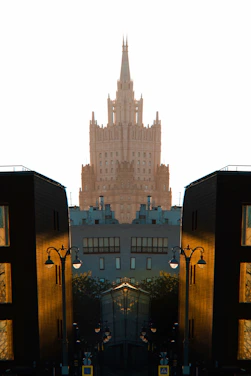 Symmetrical view of a grand skyscraper between modern buildings.