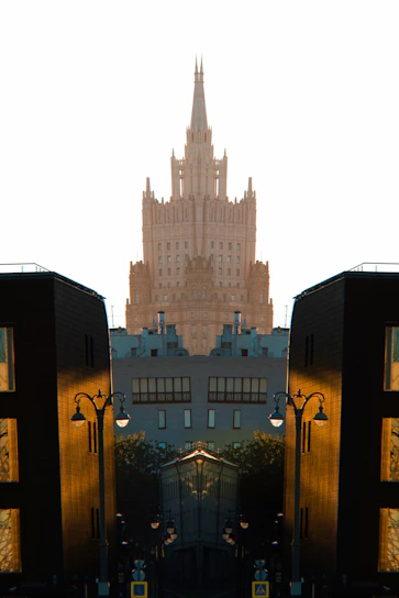 Symmetrical view of a grand skyscraper between modern buildings.