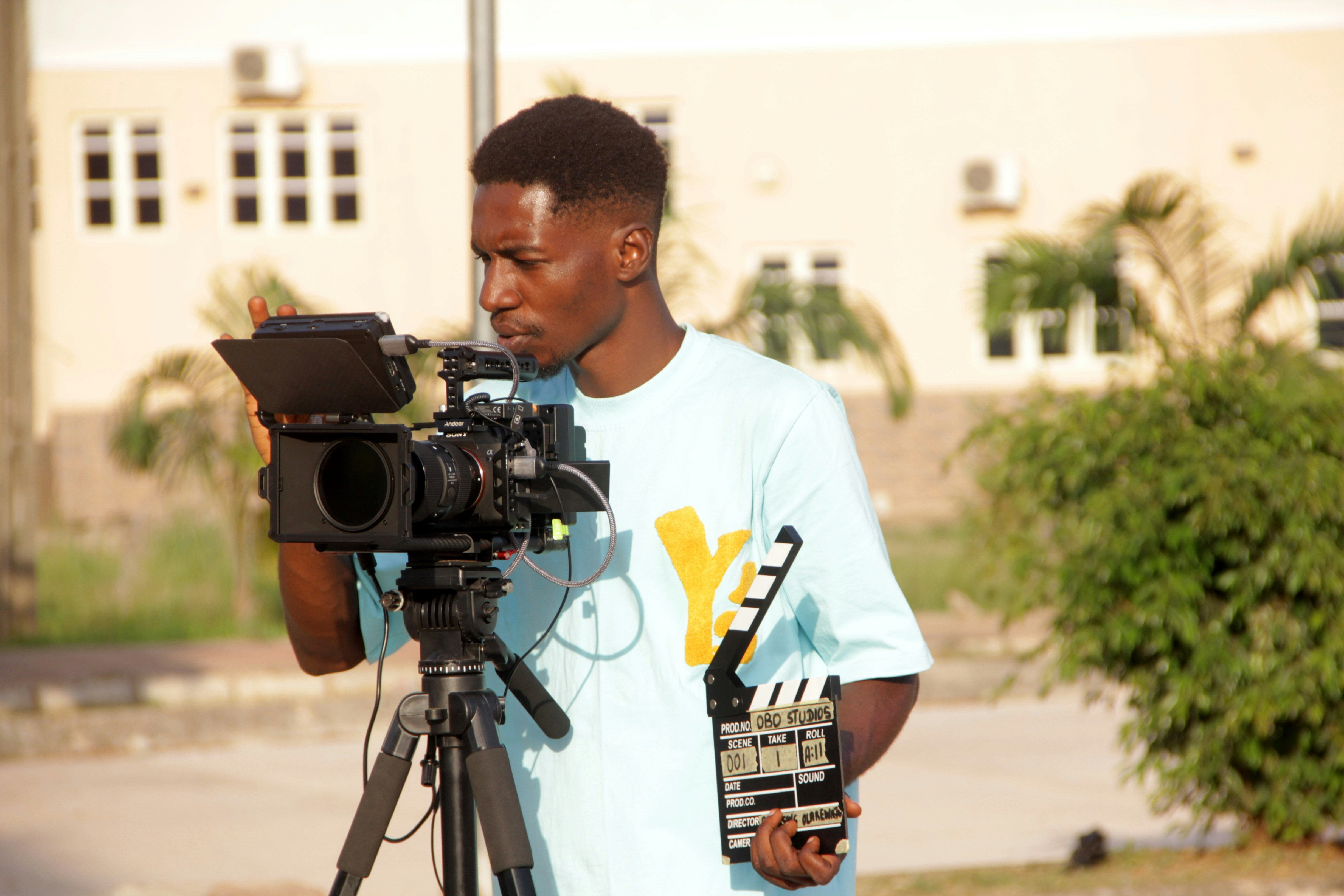 Young man operating a professional video camera on a tripod