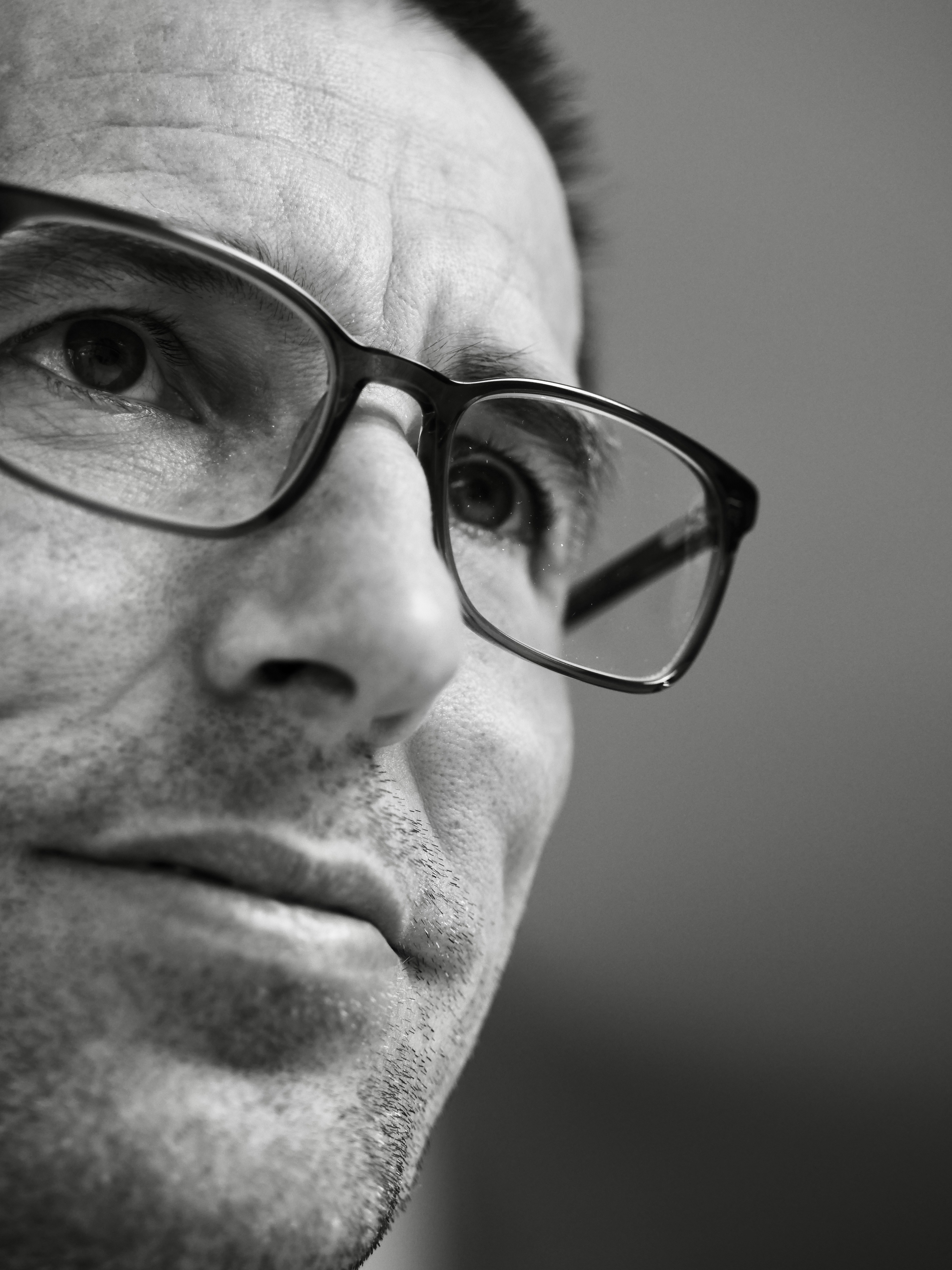 Nahaufnahme Schwarz-Weiß eines Mannes mit Brille.