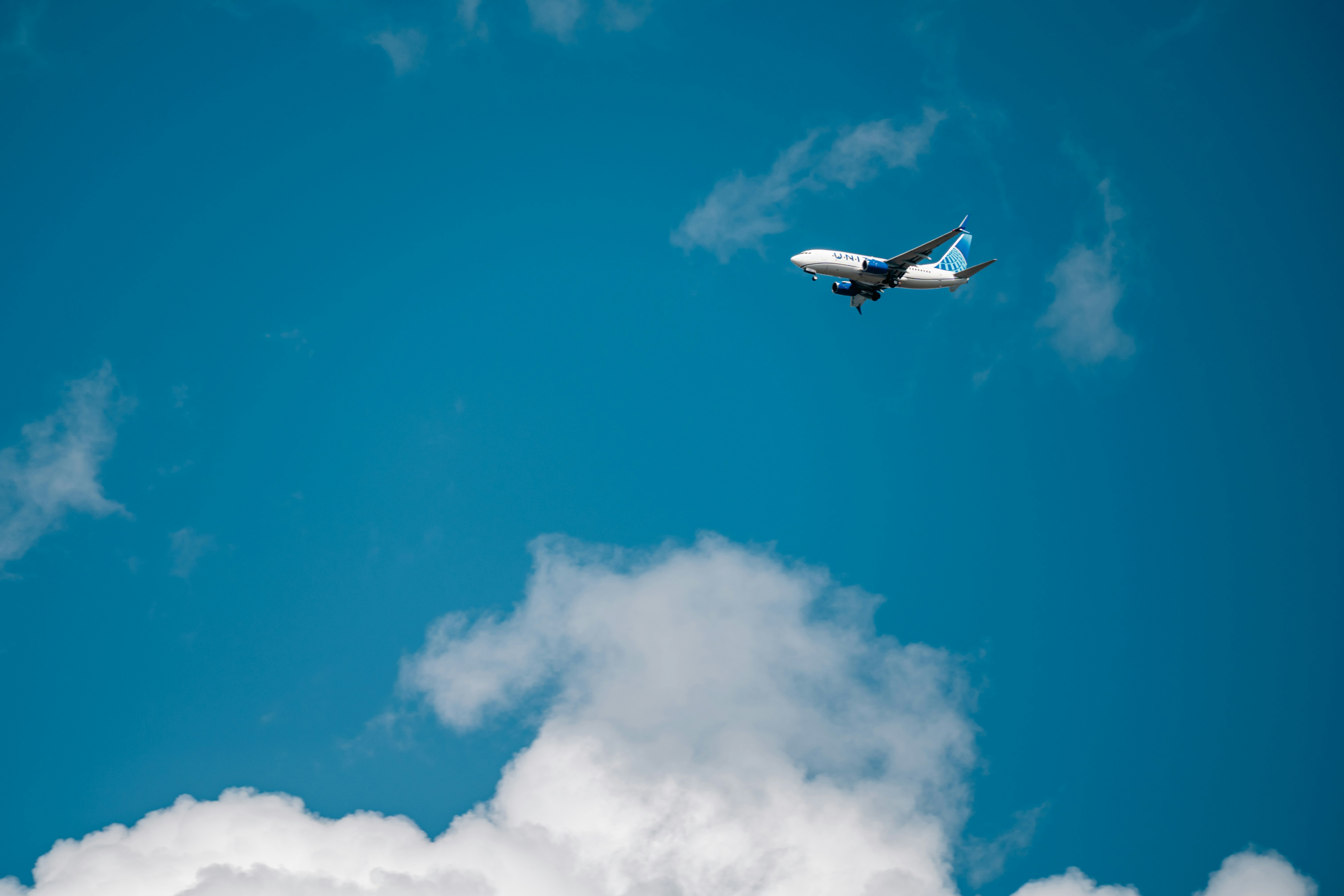 An airplane flying in a bright blue sky.