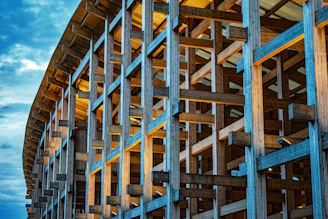Wooden beams form a large abstract structure against sky