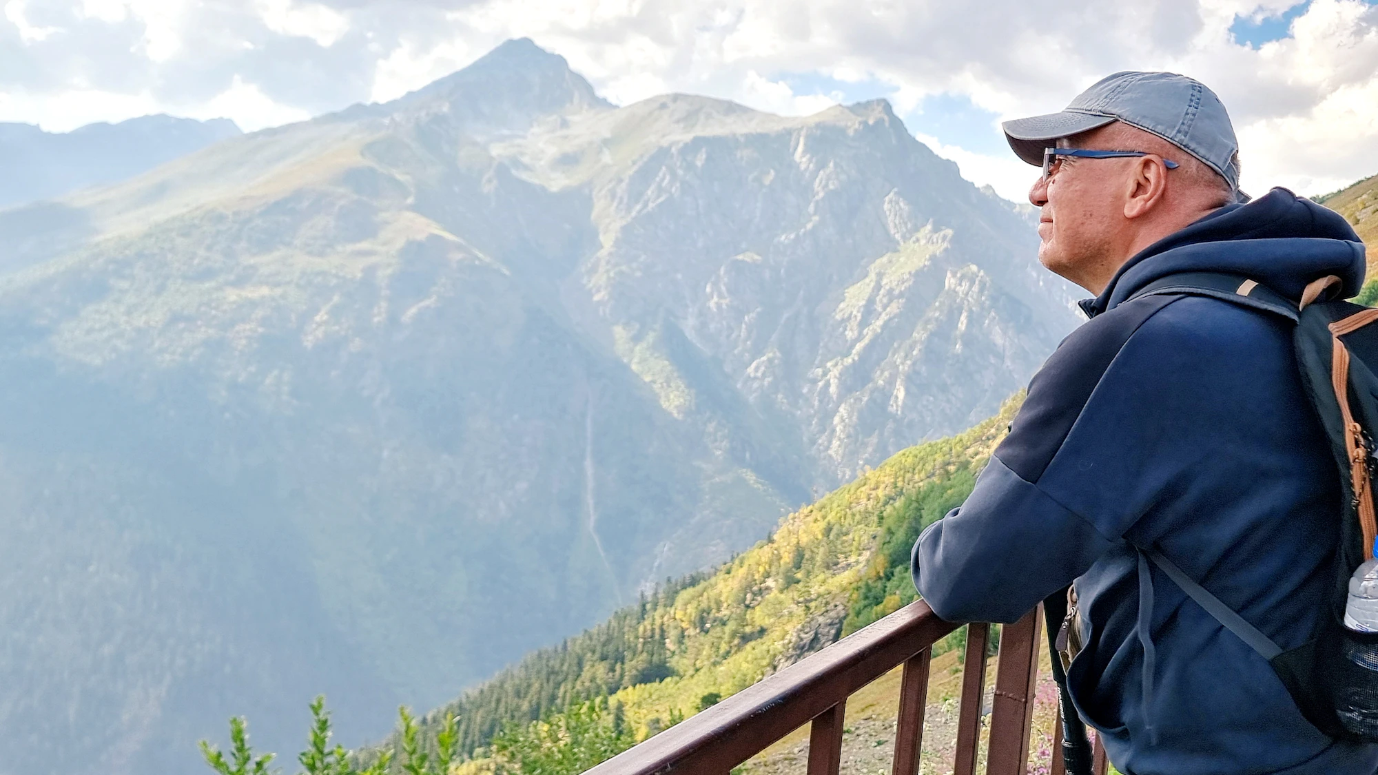 Solitary mature man at mountain overlook — clarity, longevity
