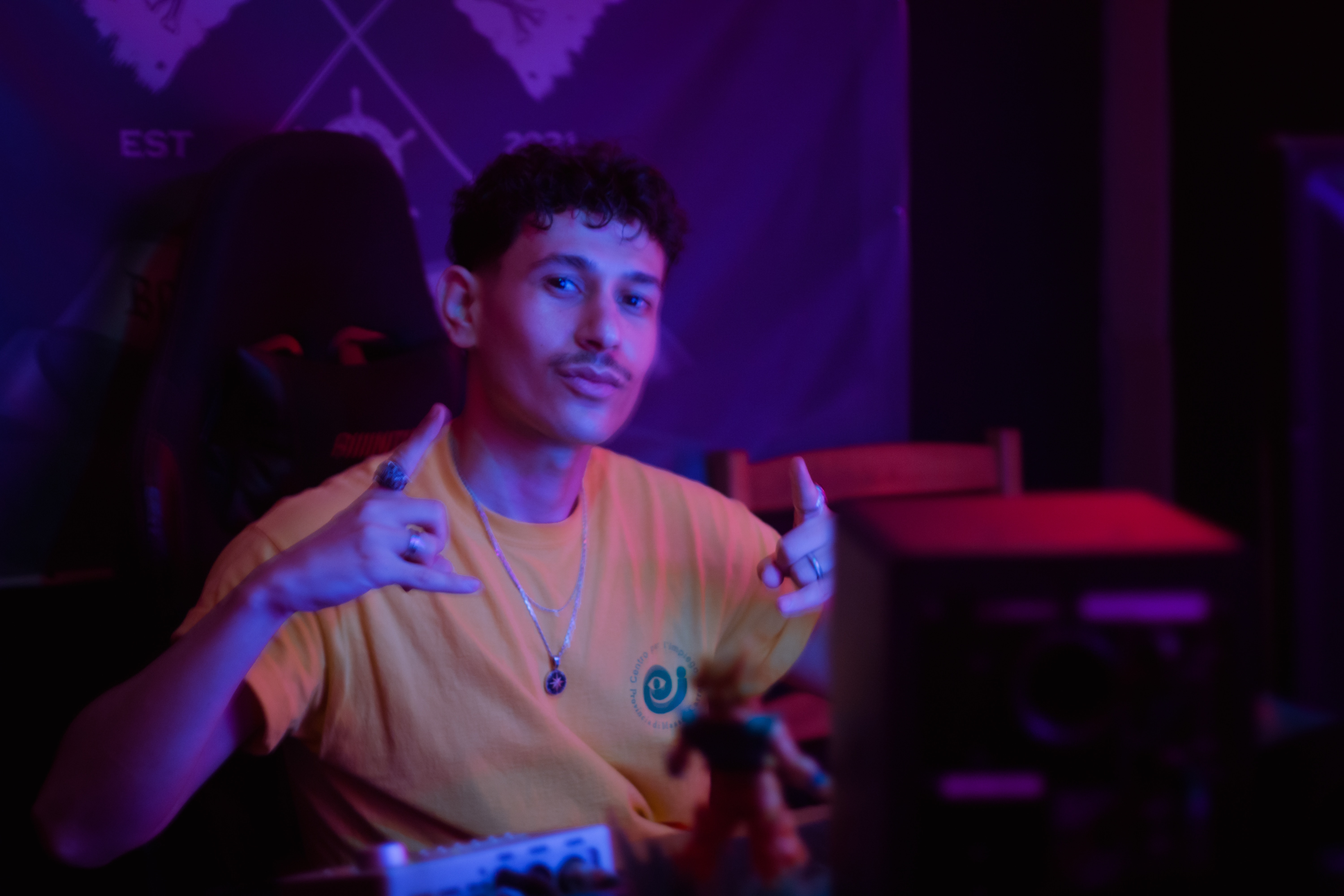 Man in yellow shirt making shaka sign.