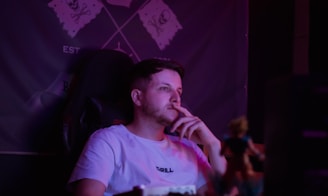 Man with hand on chin in purple light