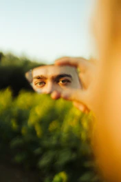 Man's eyes reflected in a handheld mirror outdoors
