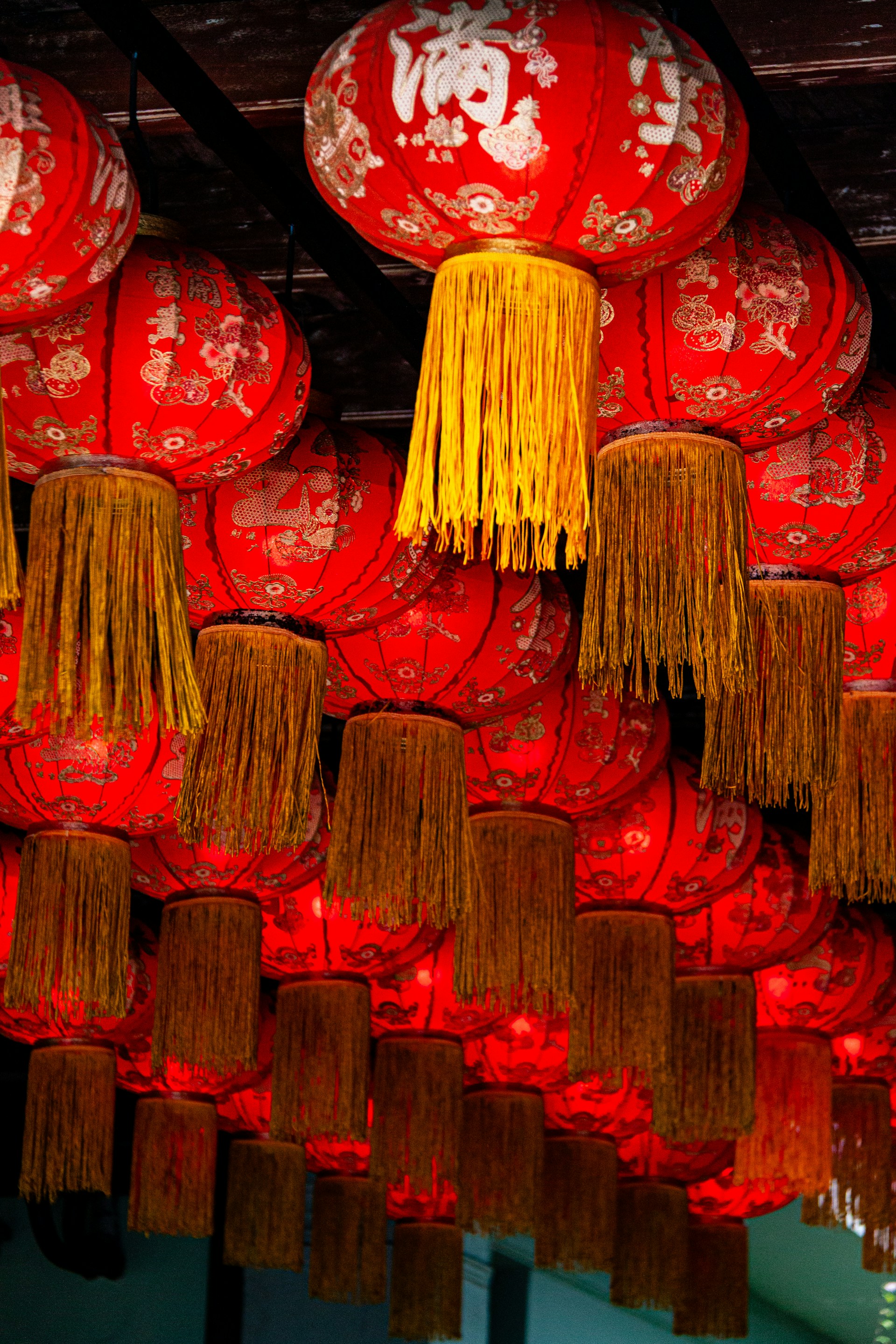 Rows of red chinese lanterns with gold tassels hang.