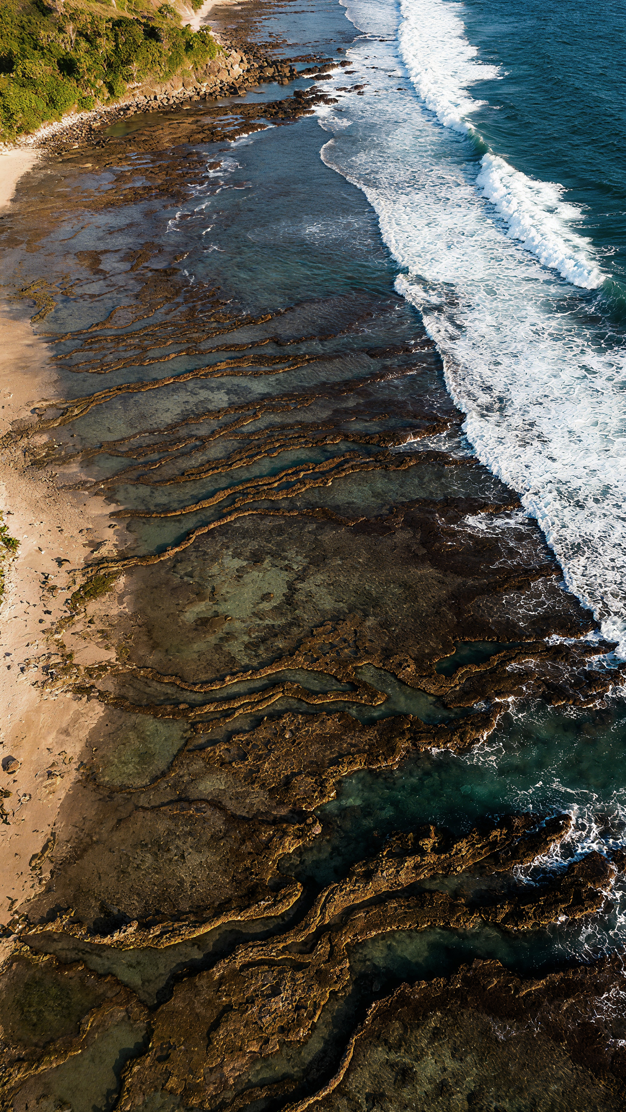 Luftaufnahme von Meereswellen, die an die felsige Küste schlagen