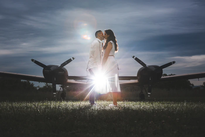Pareja observando aviones despegar al atardecer
