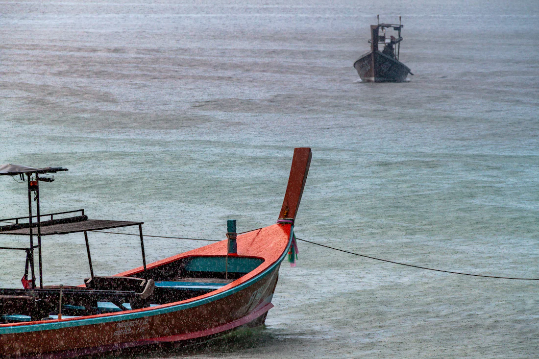เรือหางยาวจอดกลางสายฝนที่ตกลงทะเล