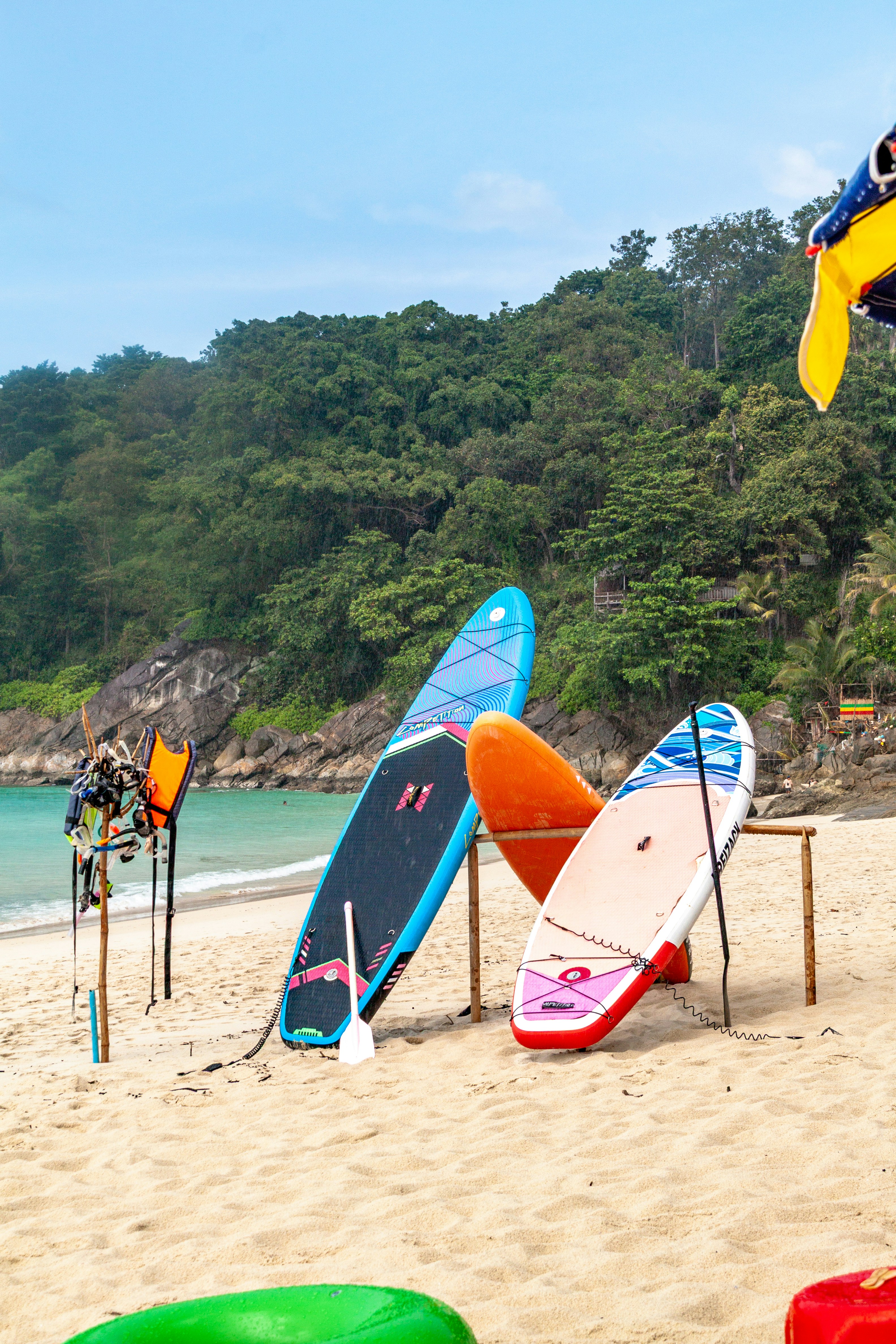 Surfboards and paddleboards on a sandy beach.