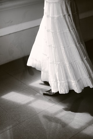 Woman in long white skirt walking on tiled floor