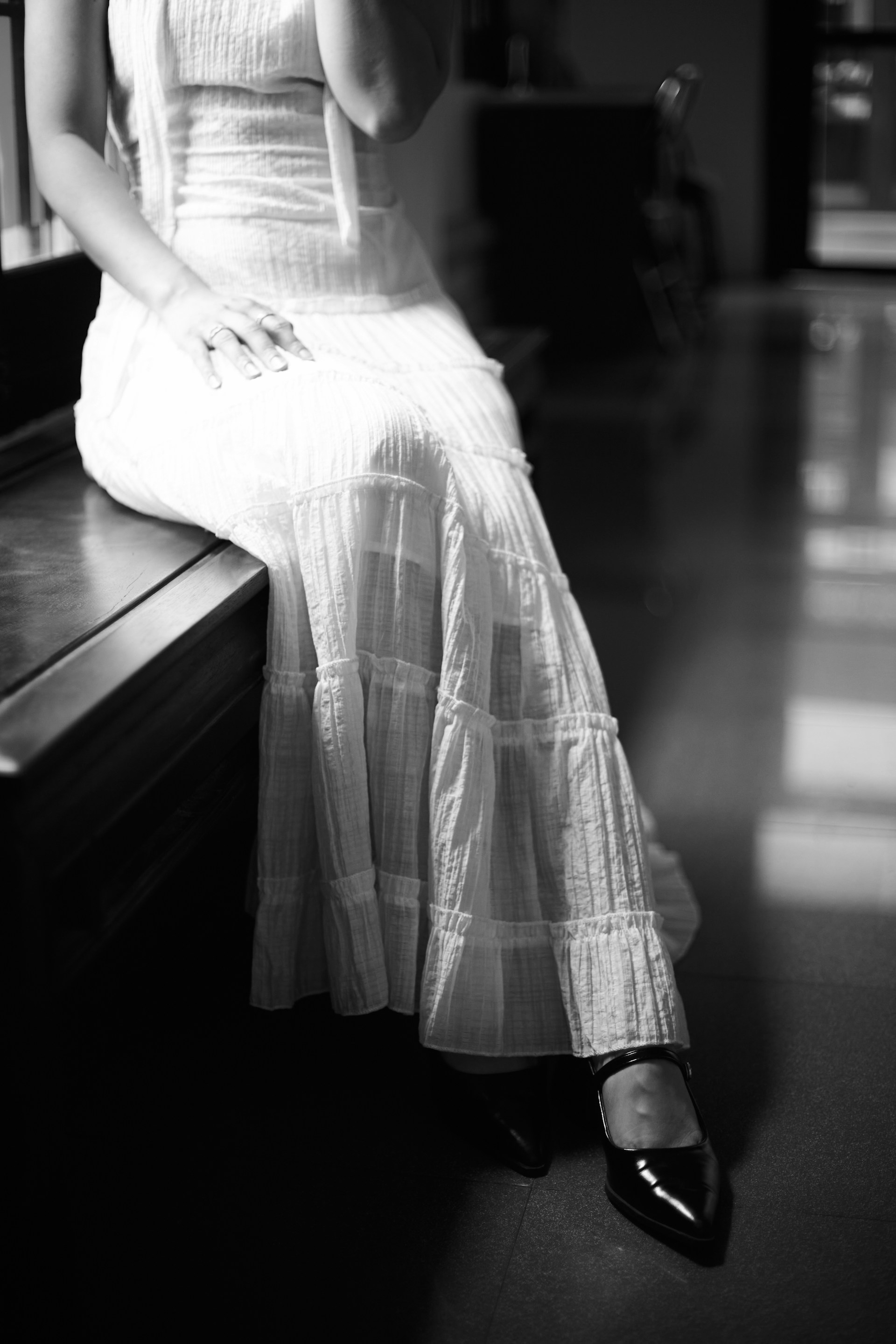 Woman in a white dress sitting on a bench