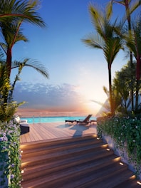 Luxury infinity pool at sunset with palm trees.