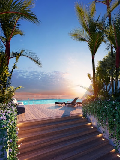 Luxury infinity pool at sunset with palm trees.