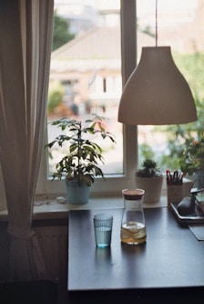A glass and pitcher of water on a table.