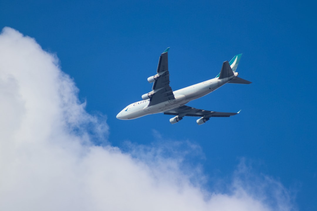 A large airplane flying through a bright blue sky.