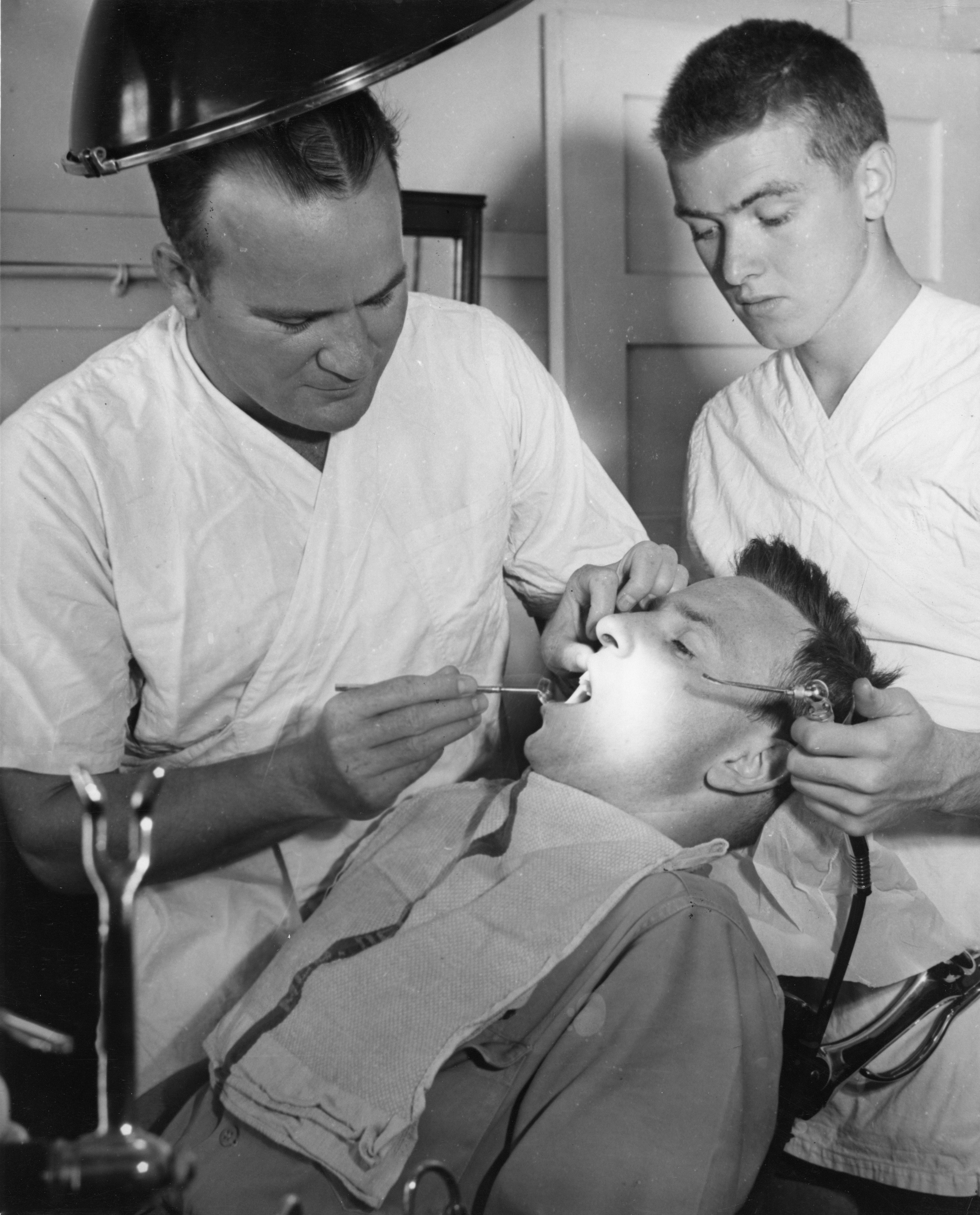 歯科医が助手がいる状態で患者の治療をしている