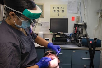 Dentist examining patient's teeth with tools.