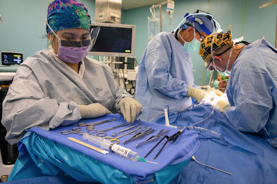 Surgeons operating with medical instruments laid out