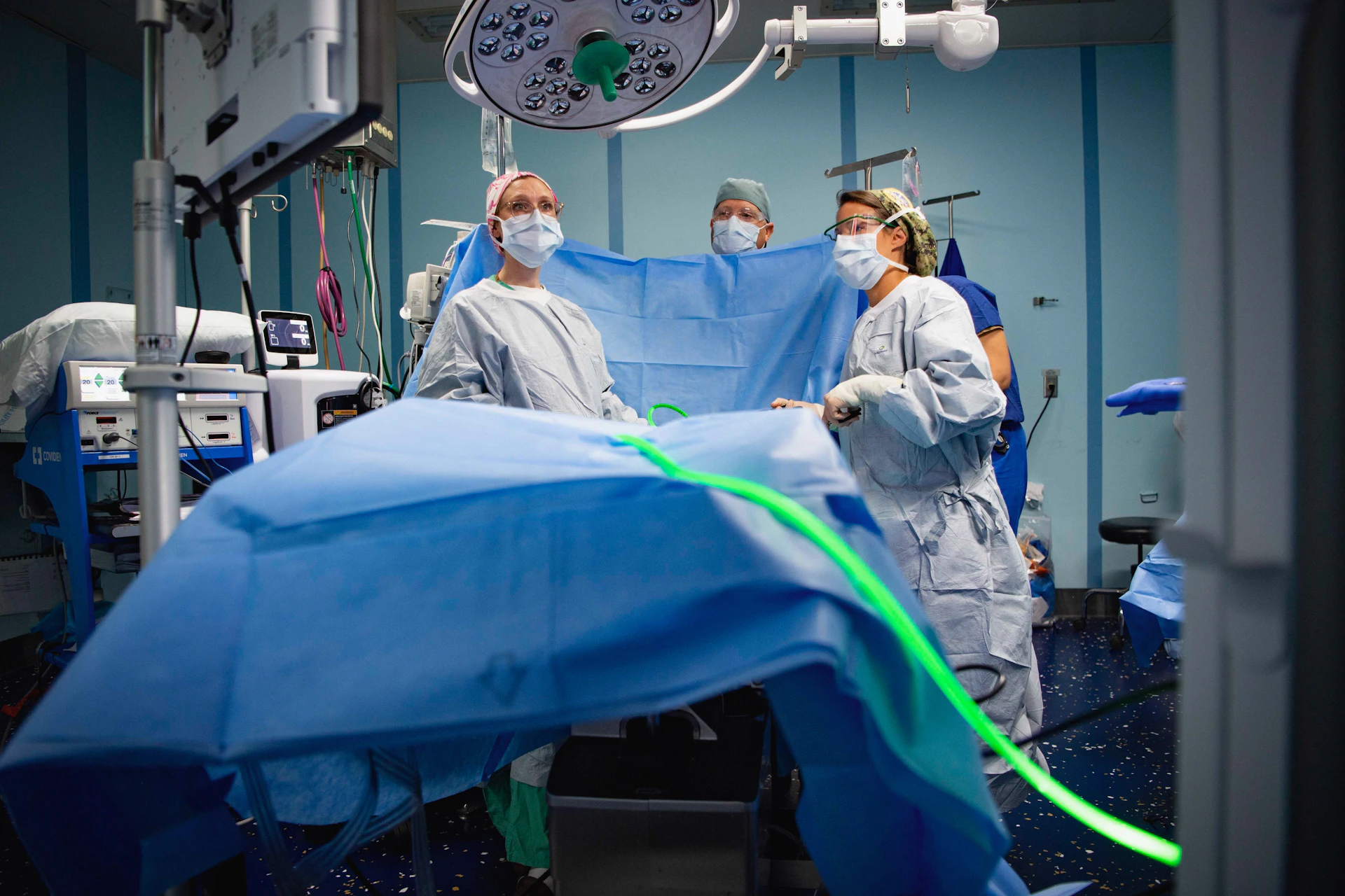 Surgeons in sterile gowns performing a medical operation