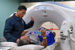 Medical professional assists patient during ct scan procedure.