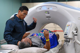 Medical professional assists patient during ct scan procedure.