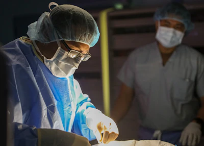 Surgeons in sterile gowns and masks performing surgery