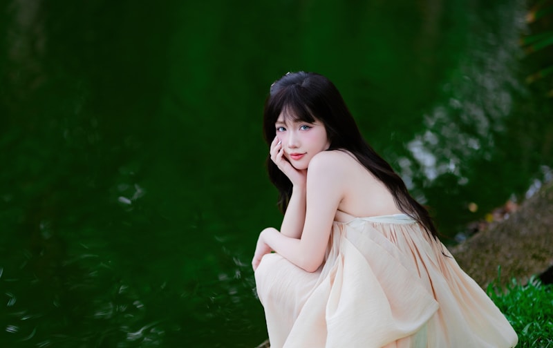 Young woman in a light dress by a green pond