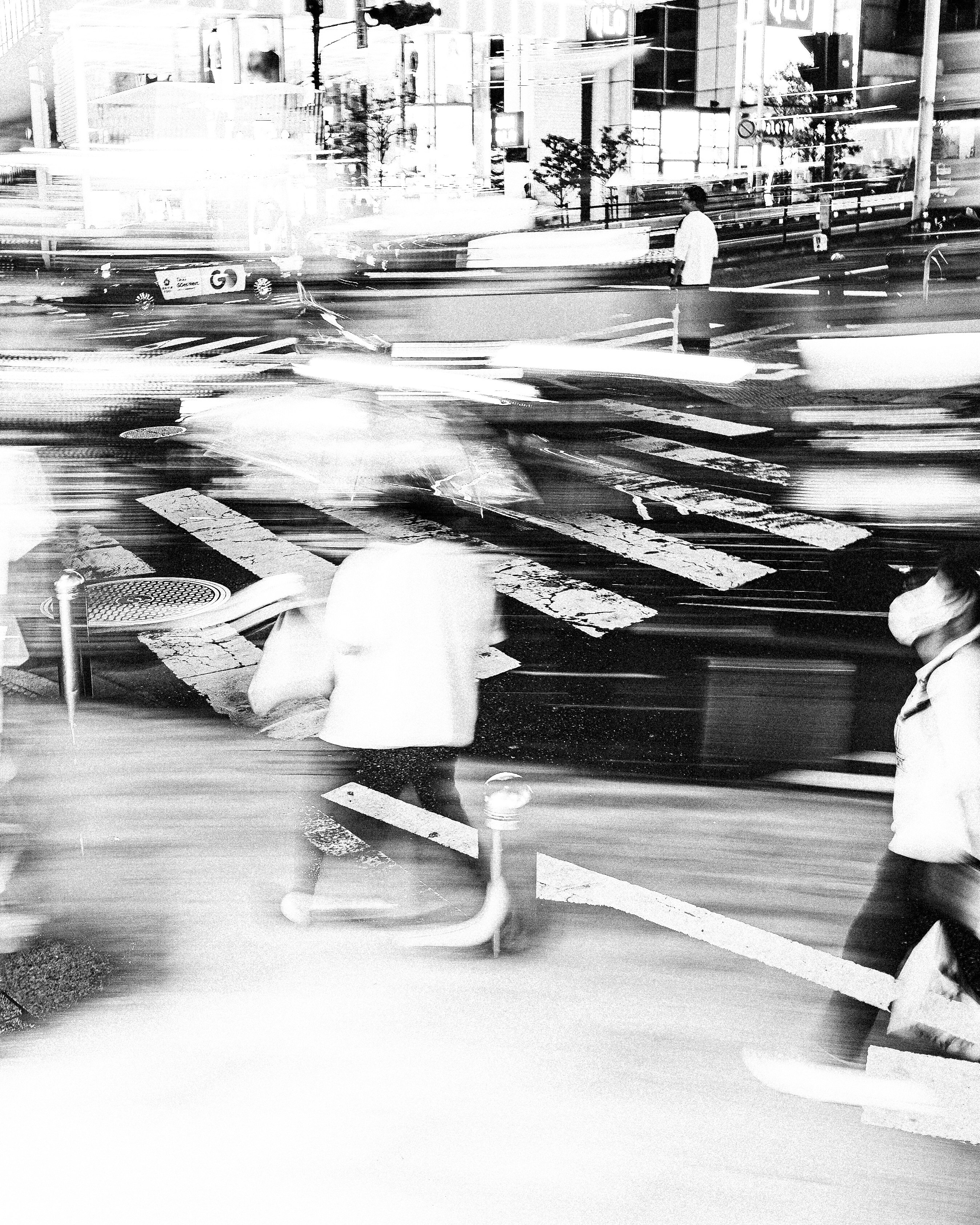 Blurred figures crossing a busy street at night