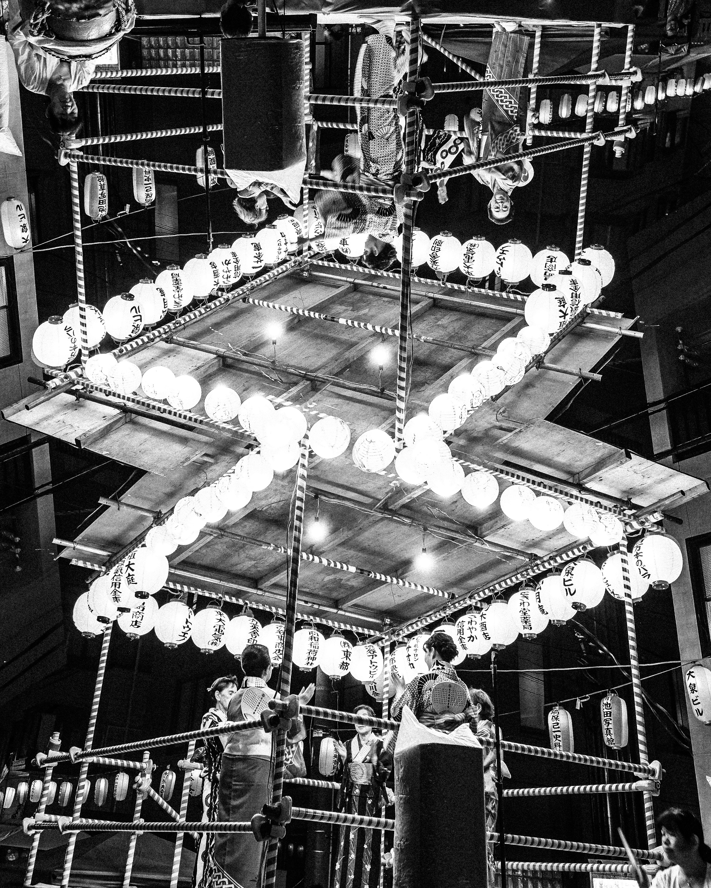People in traditional clothing carrying illuminated festival float