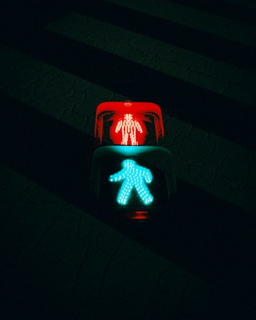 Pedestrian crossing signal showing red and green lights at a crosswalk, a cue for Las Vegas drivers to stay alert near school crossings