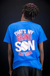 Person wearing a blue t-shirt with baseball graphic.
