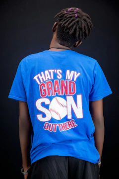 Person wearing a blue t-shirt with baseball graphic.