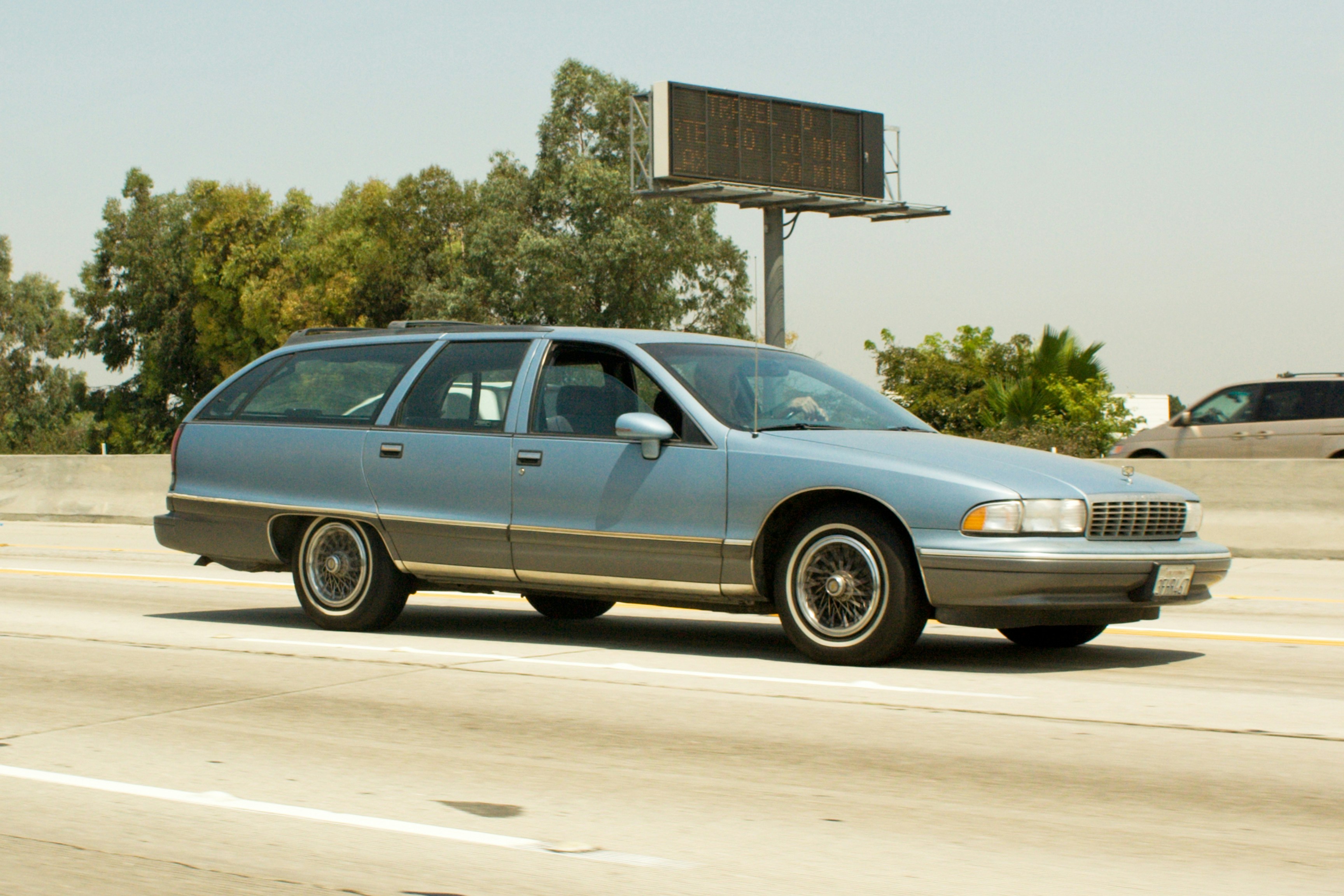Light blue station wagon driving on highway