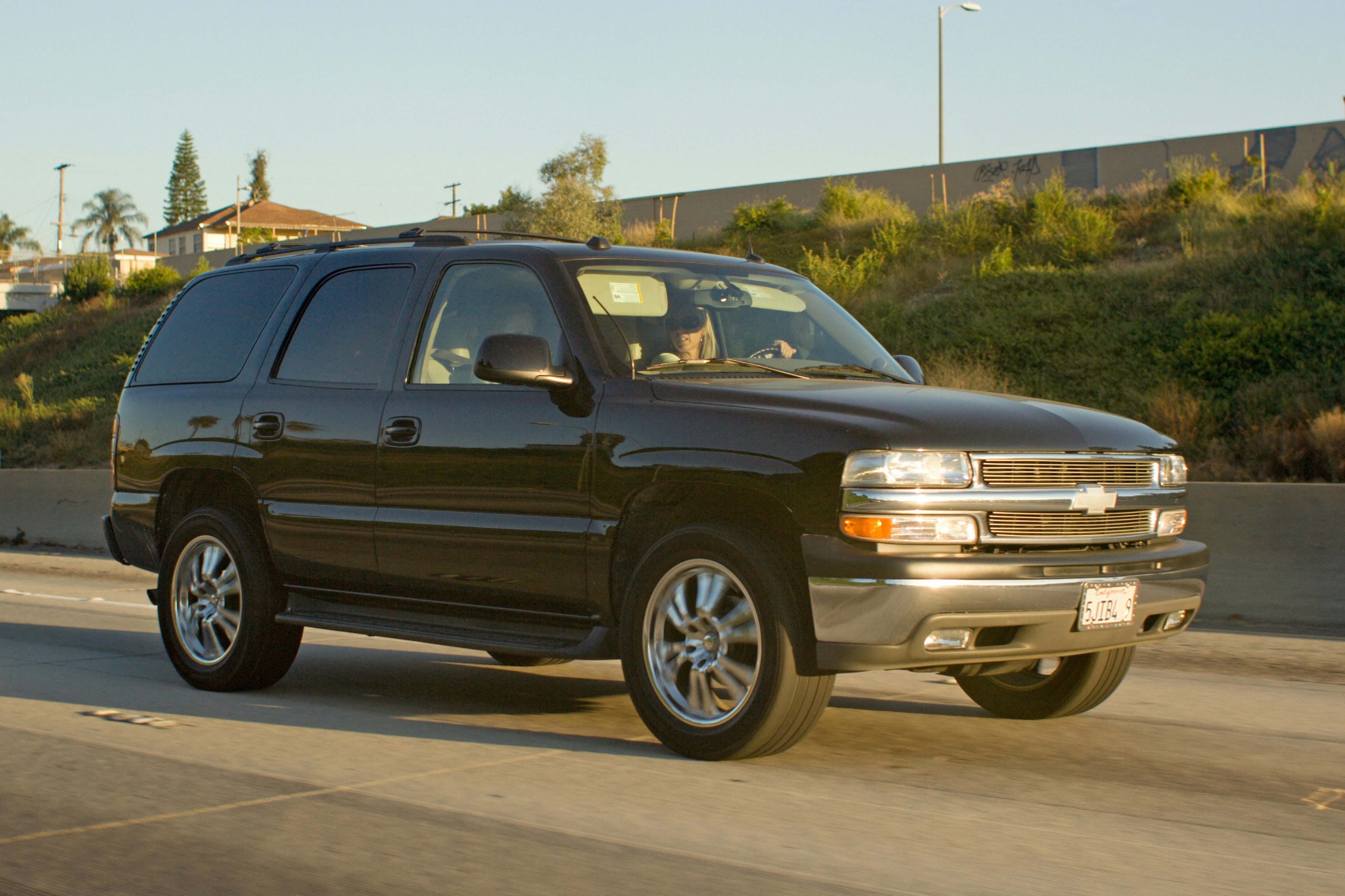 Black chevrolet suburban driving on a sunny highway