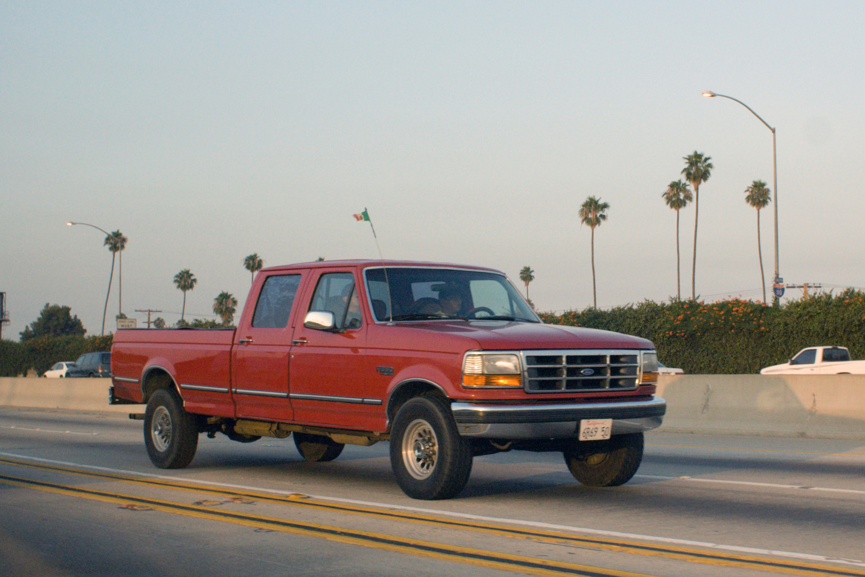 Red pickup truck driving on a highway.