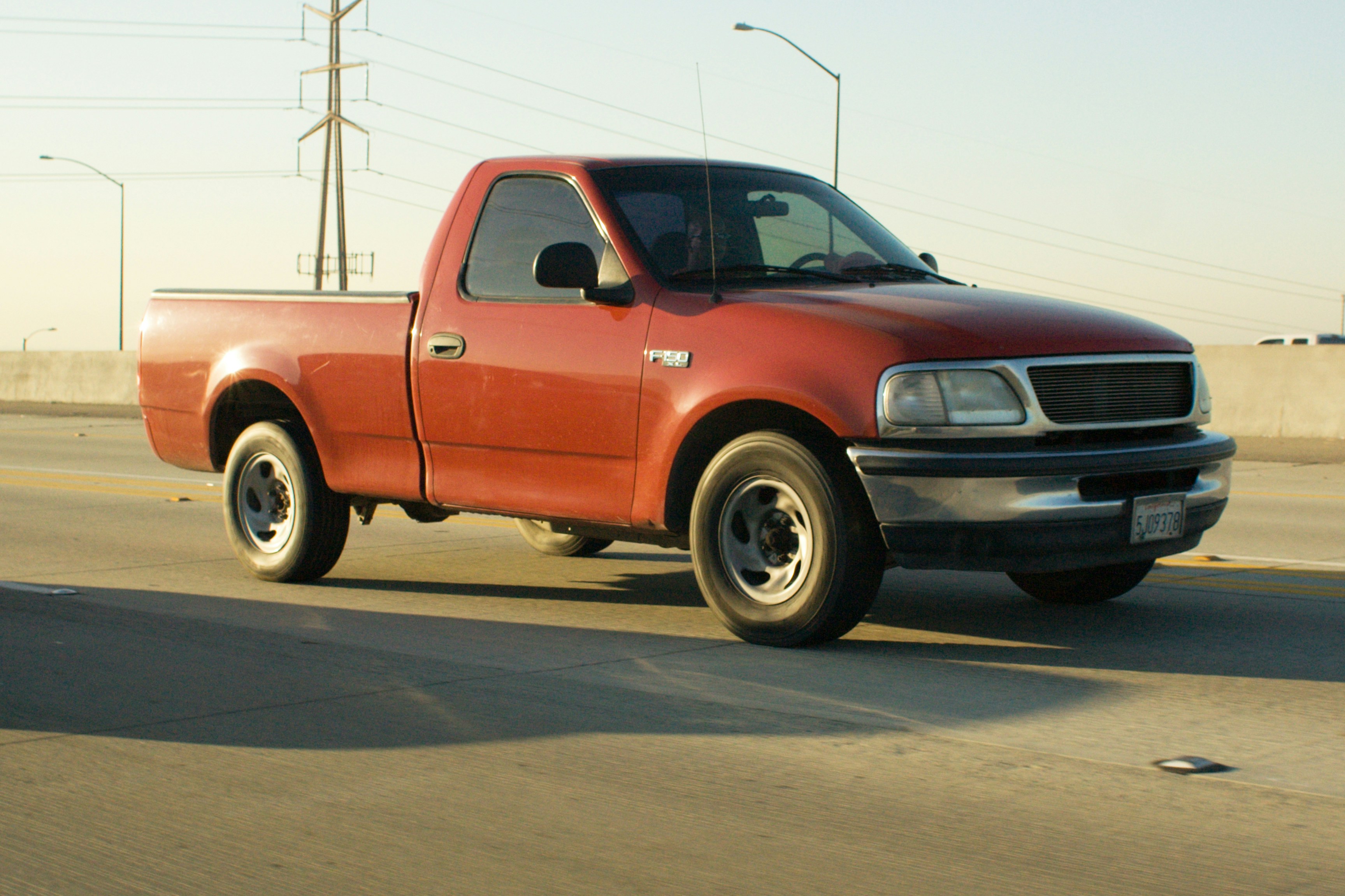 Red pickup truck driving on a highway