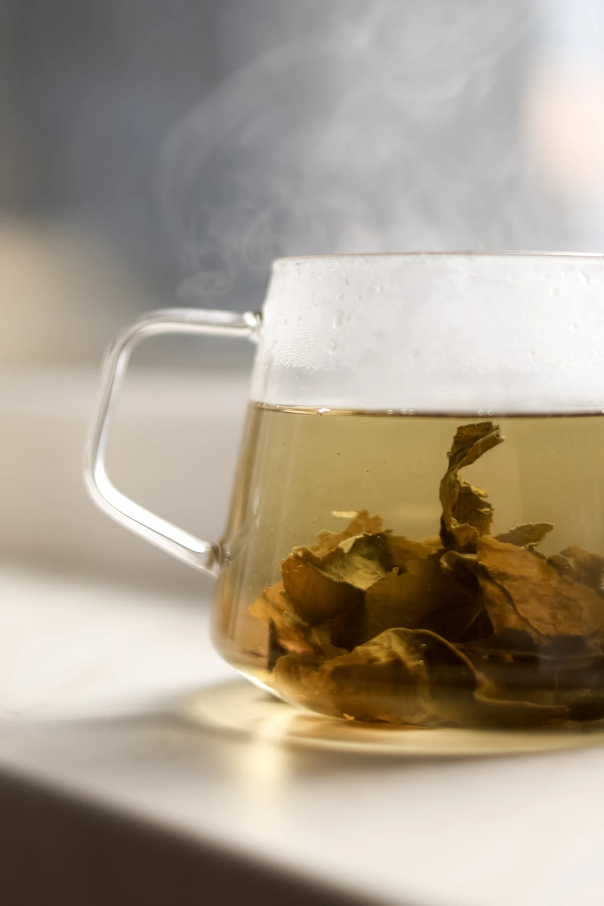 Steaming herbal tea in a glass mug