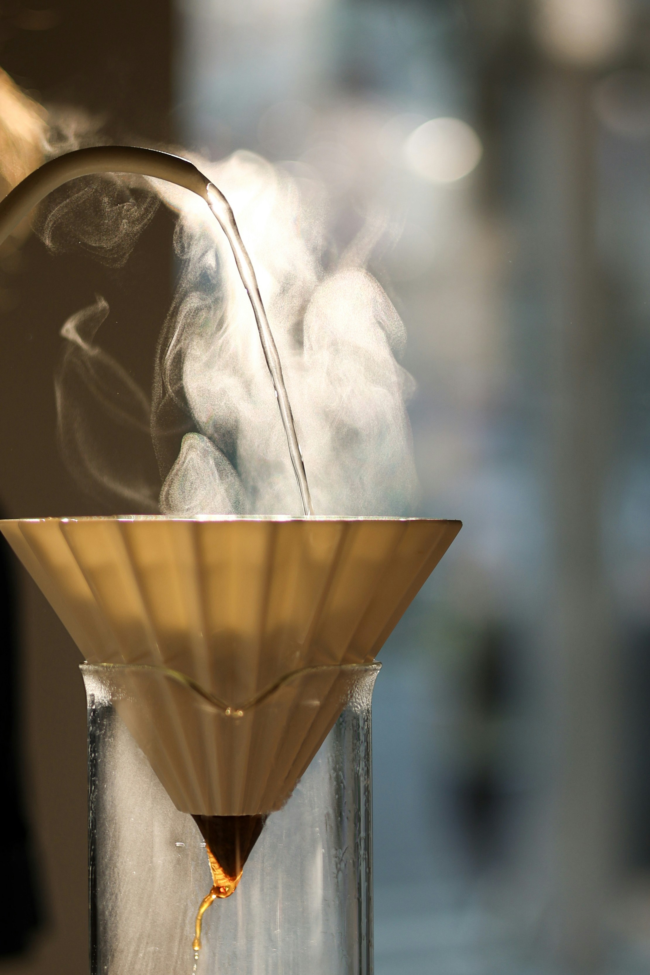 Hot water being poured from a gooseneck kettle into a coffee filter during pour-over brewing