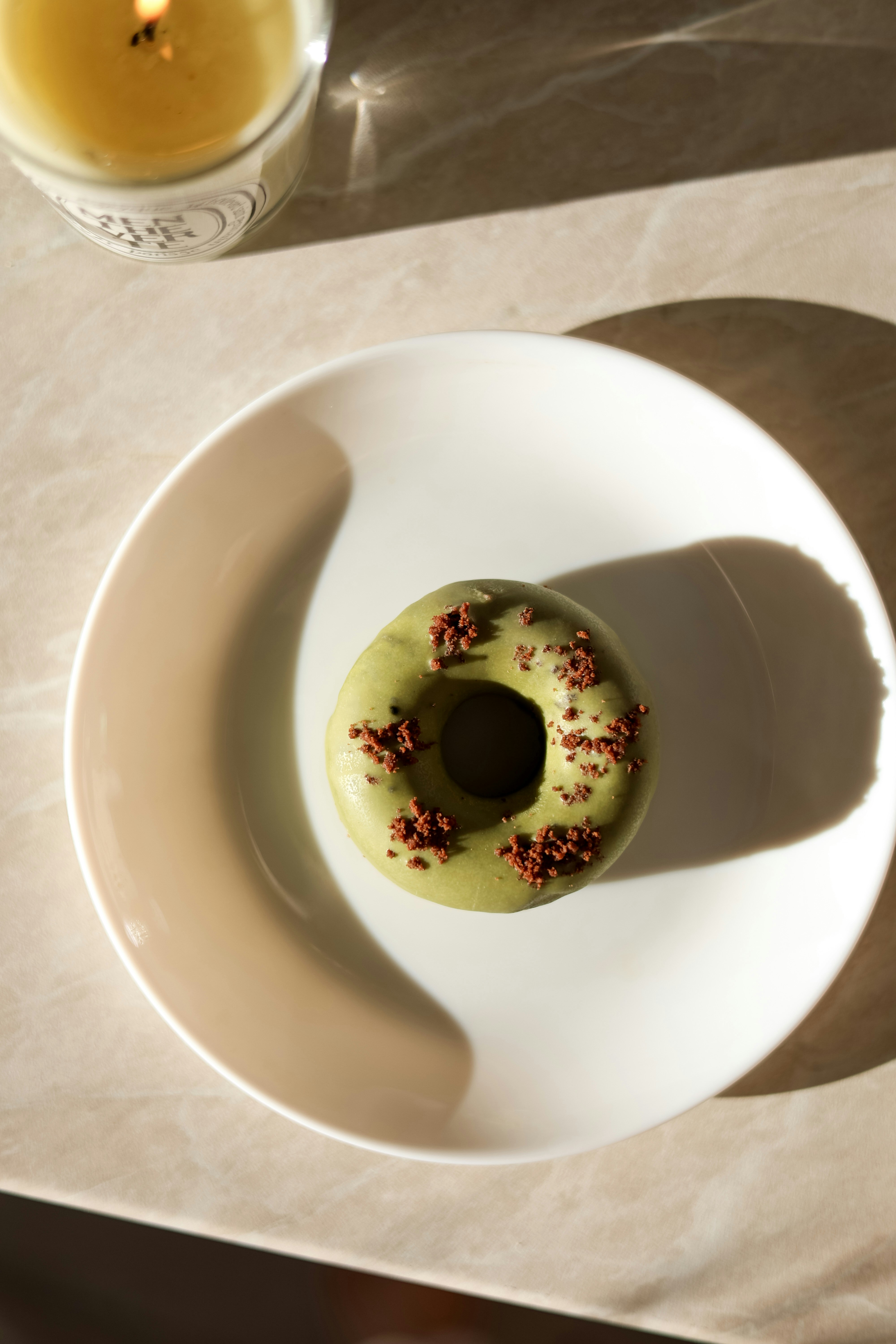 Rosquinha verde fosca com chocolate granulado no prato