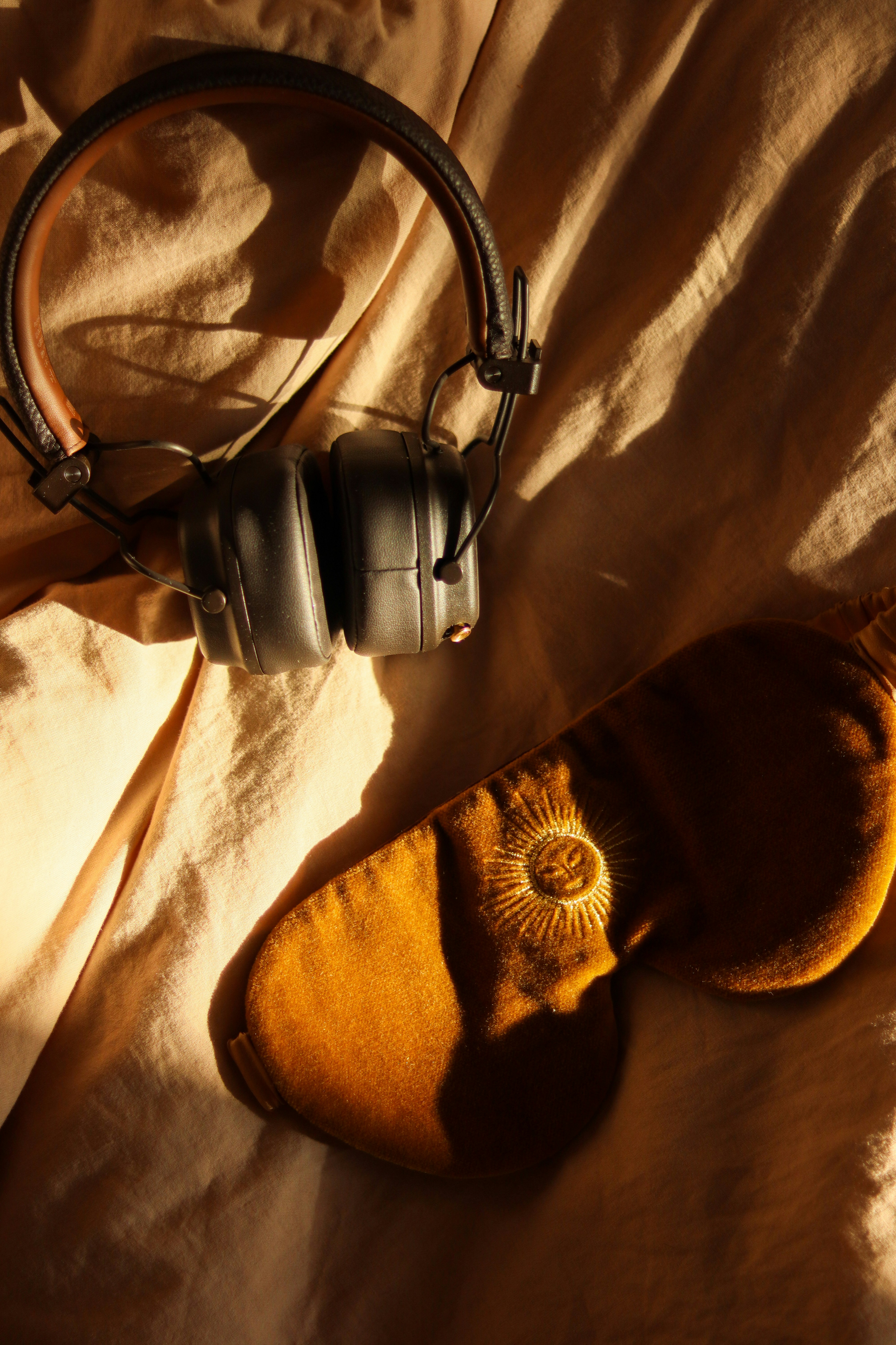 Headphones and eye mask on wrinkled fabric