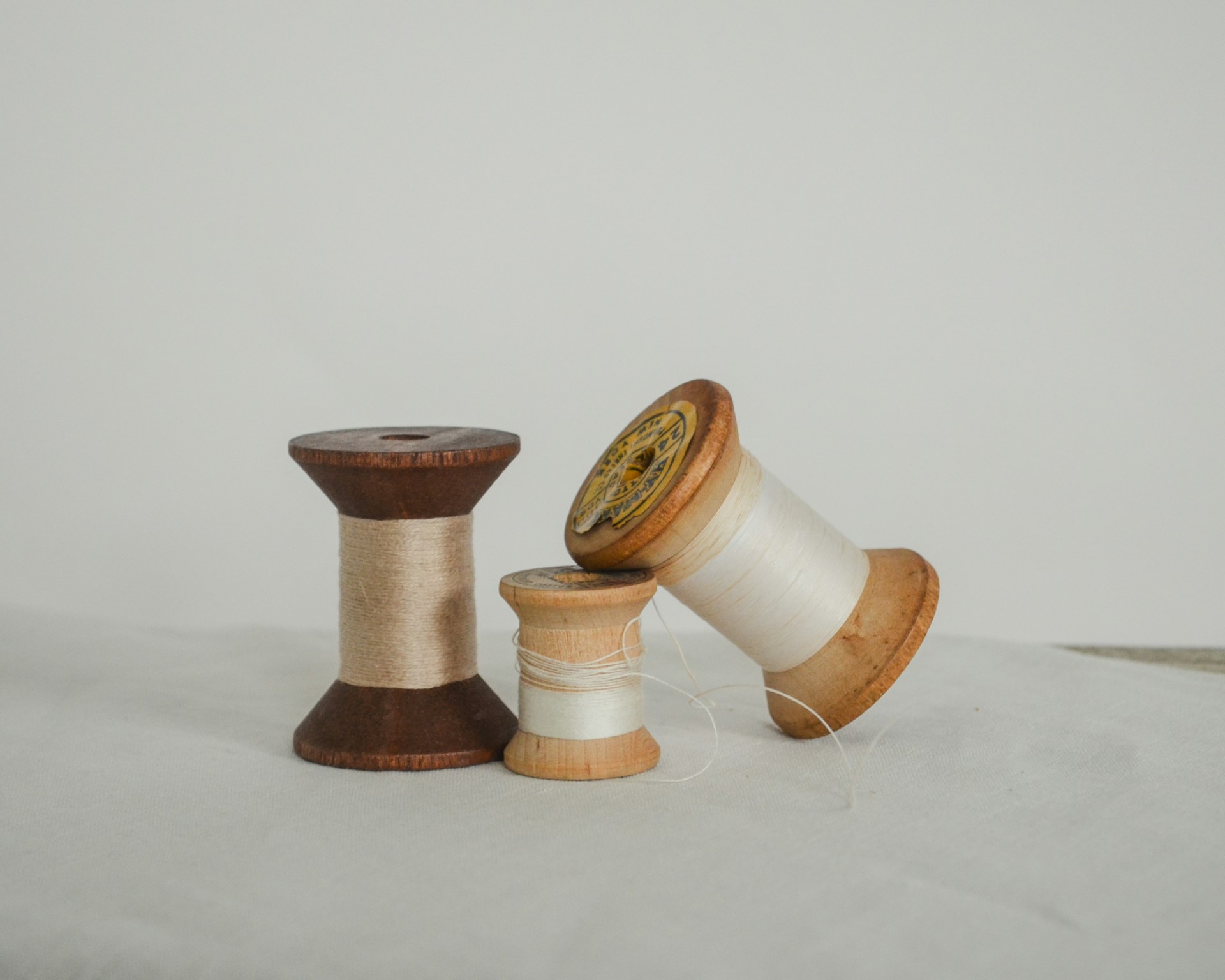 Three spools of thread on a white surface.