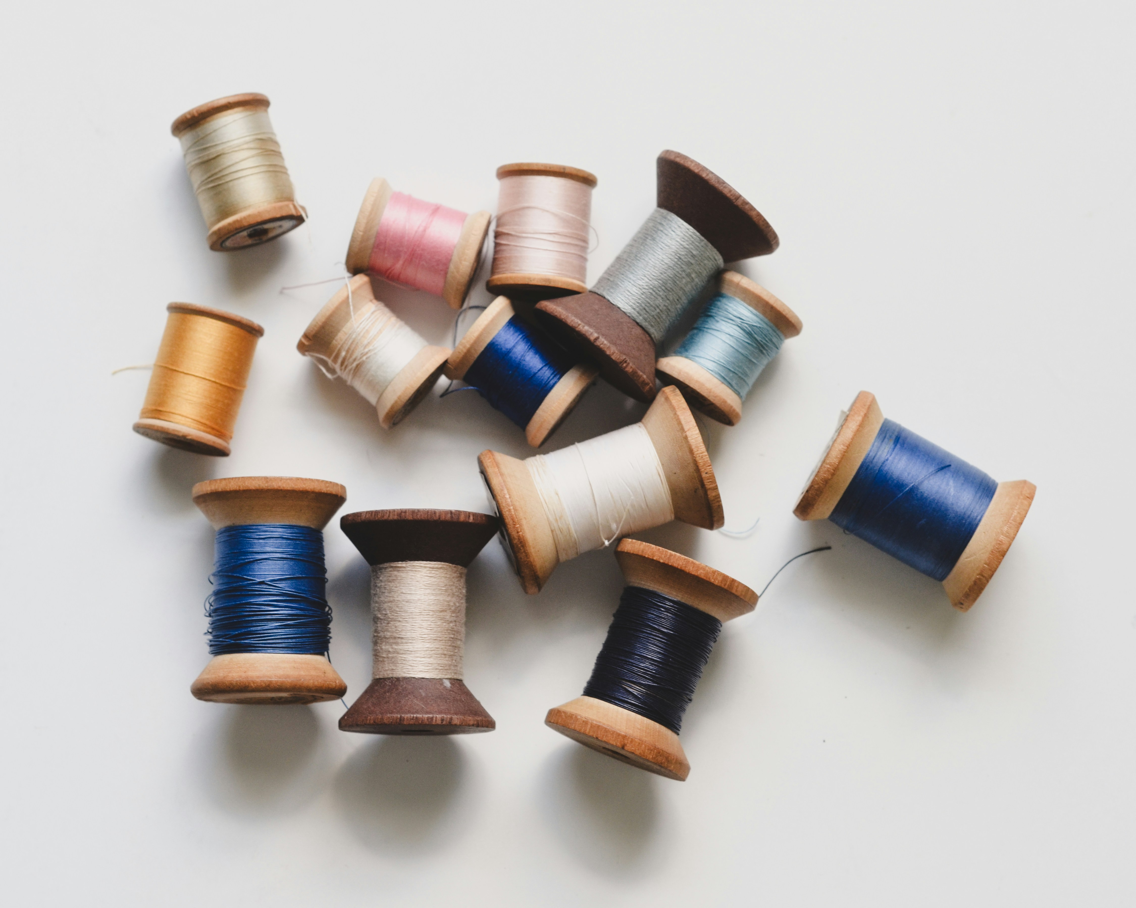 Colorful thread spools arranged on white background