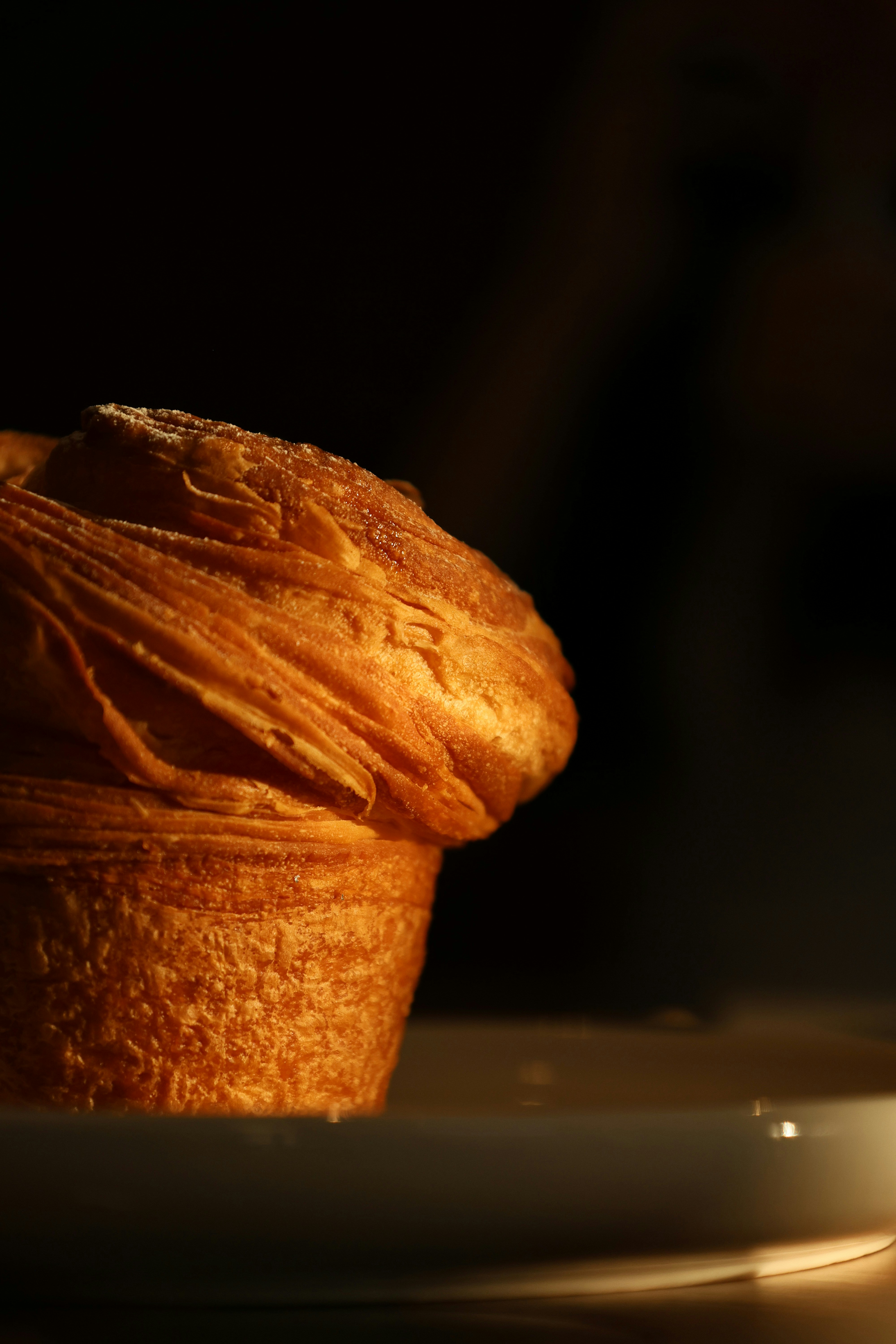 Golden brown pastry with flaky layers on white plate