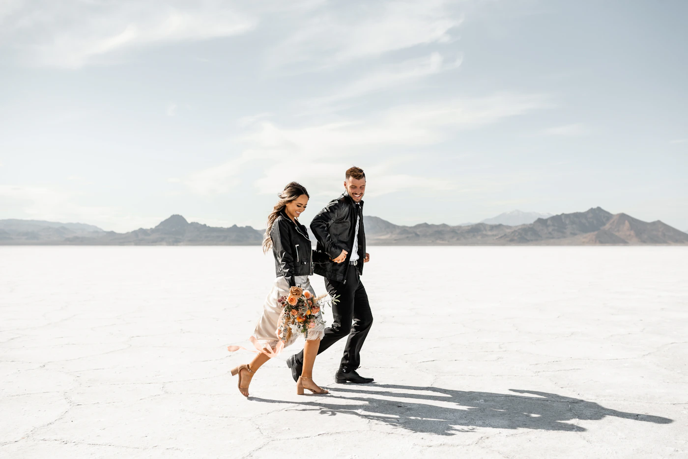 Couple in wedding ceremony attire in the open Dubai desert in the cool season, the golden afternoon light and the comfortable temperature creating ideal conditions for an extended ceremony and portrait session