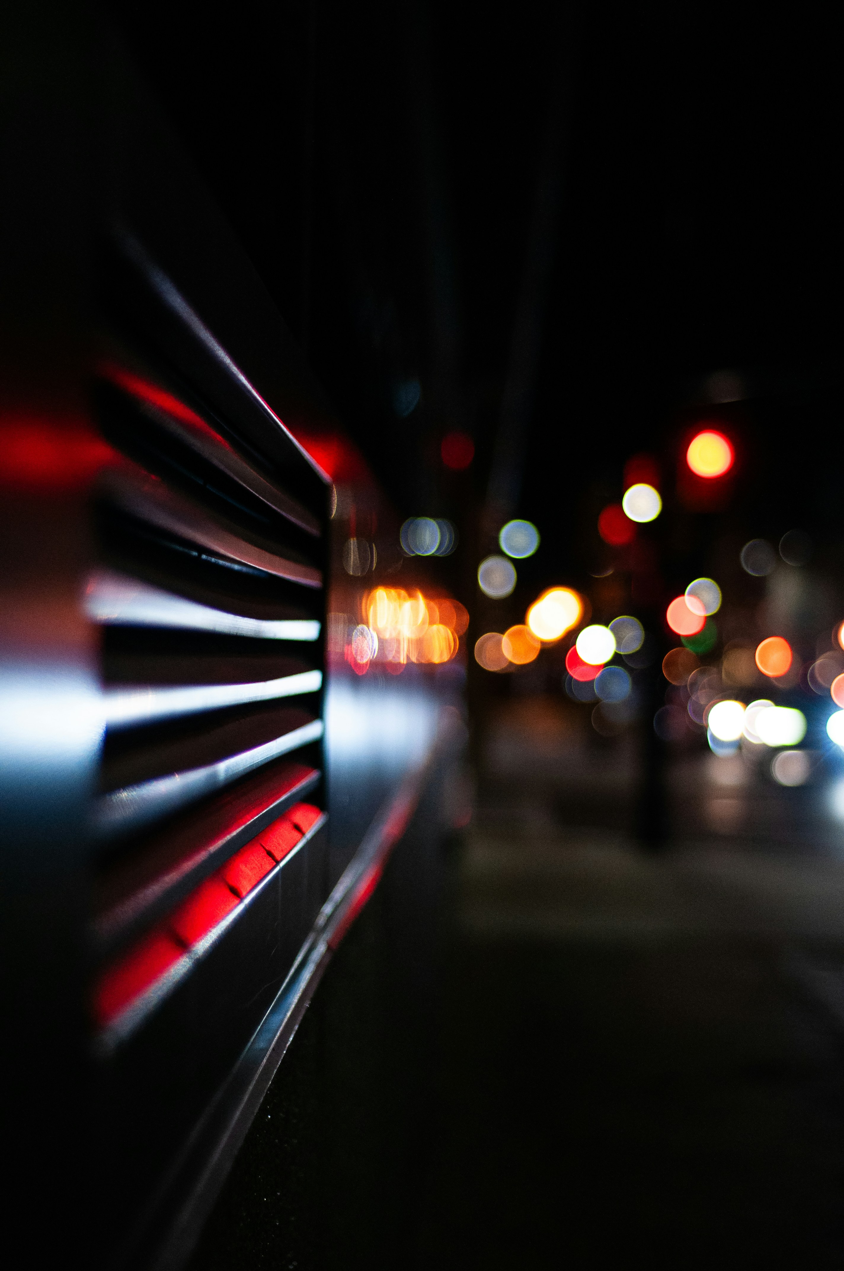 Blurred city lights at night with metal grate foreground. photo