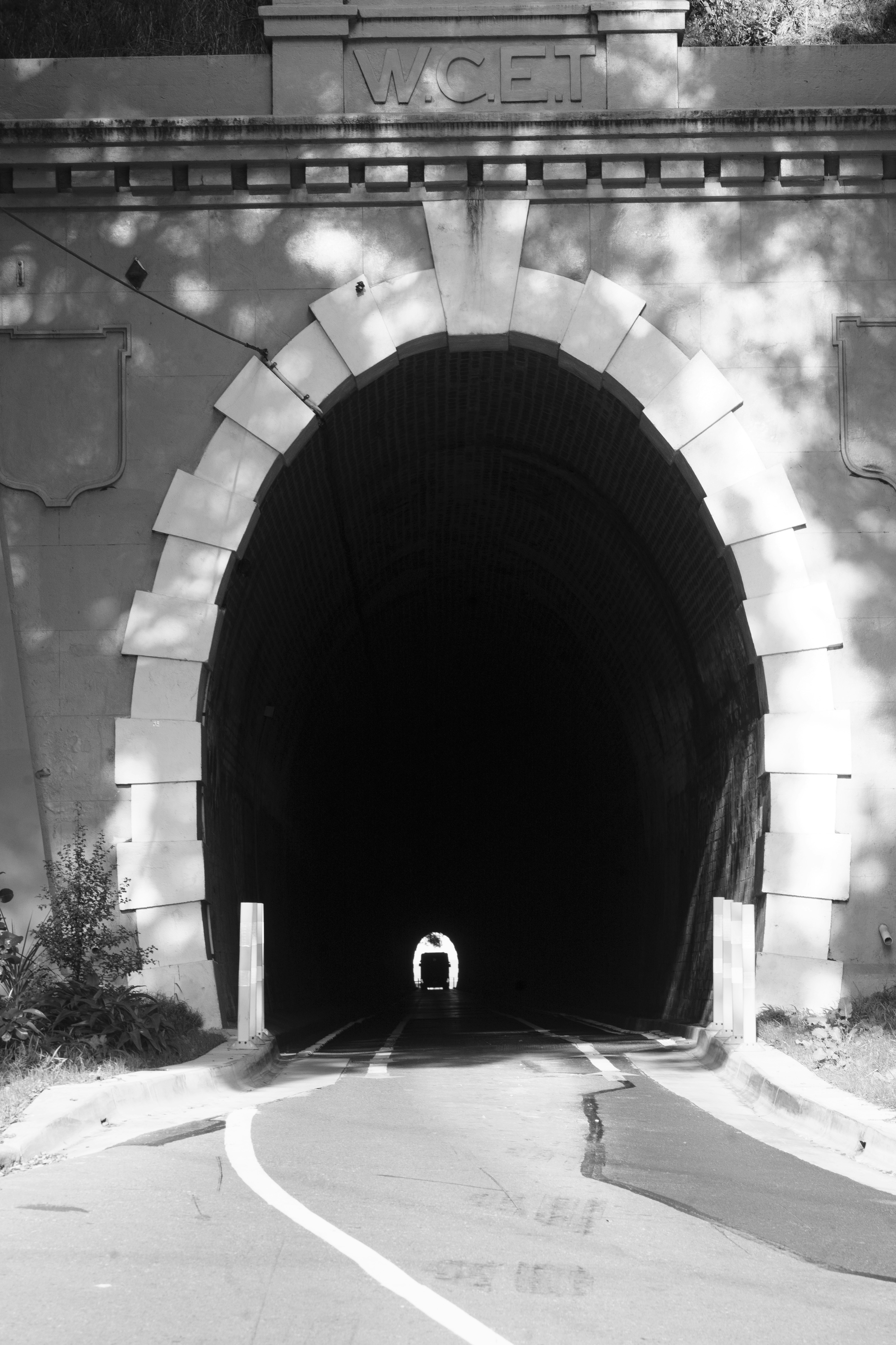 Entrance to a dark tunnel with light at the end.