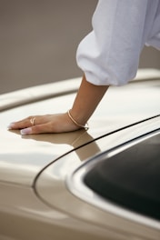 Woman's hand resting on a car roof